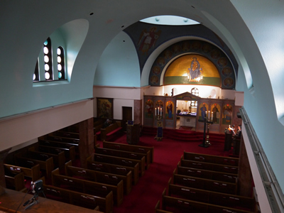 The nave of the church seen from the balcony, a red carpet leading toward the apse.